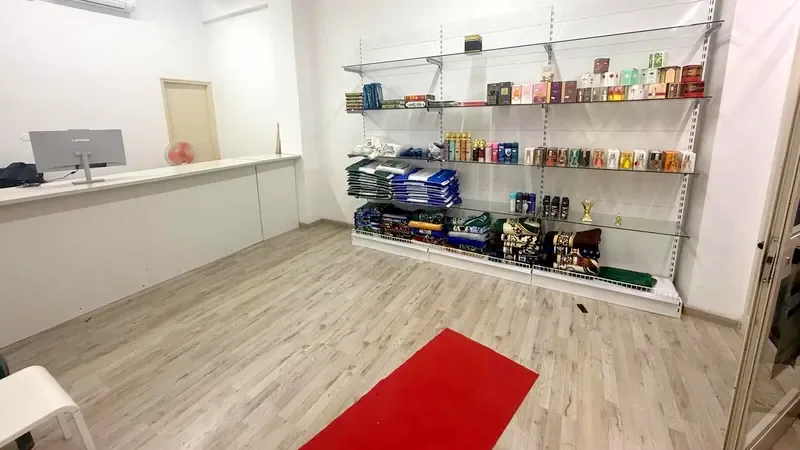 L'interno del negozio in Via Livilla: scaffali con profumi, tappeti e articoli per il pellegrinaggio